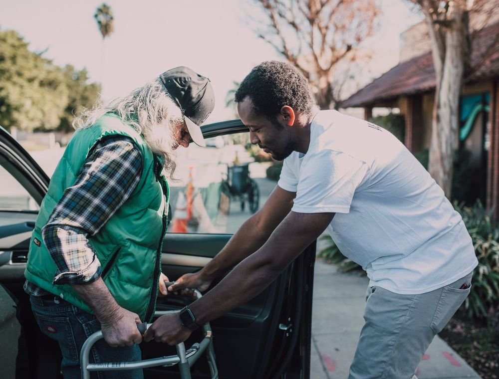 Volunteer assisting an older adult during a community-care activity