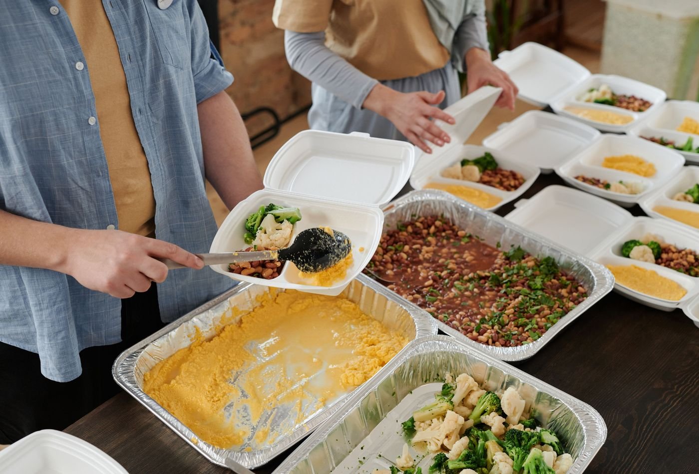 Volunteers preparing nutritious meal boxes for community distribution