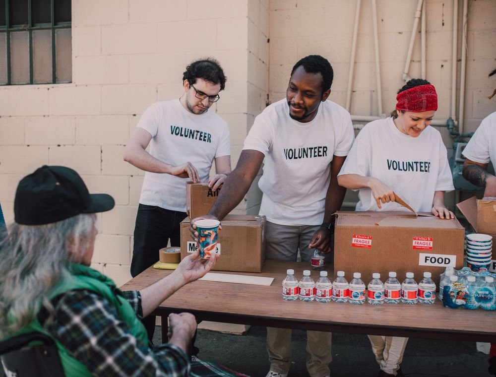 Community volunteers distributing food and water at an outreach event