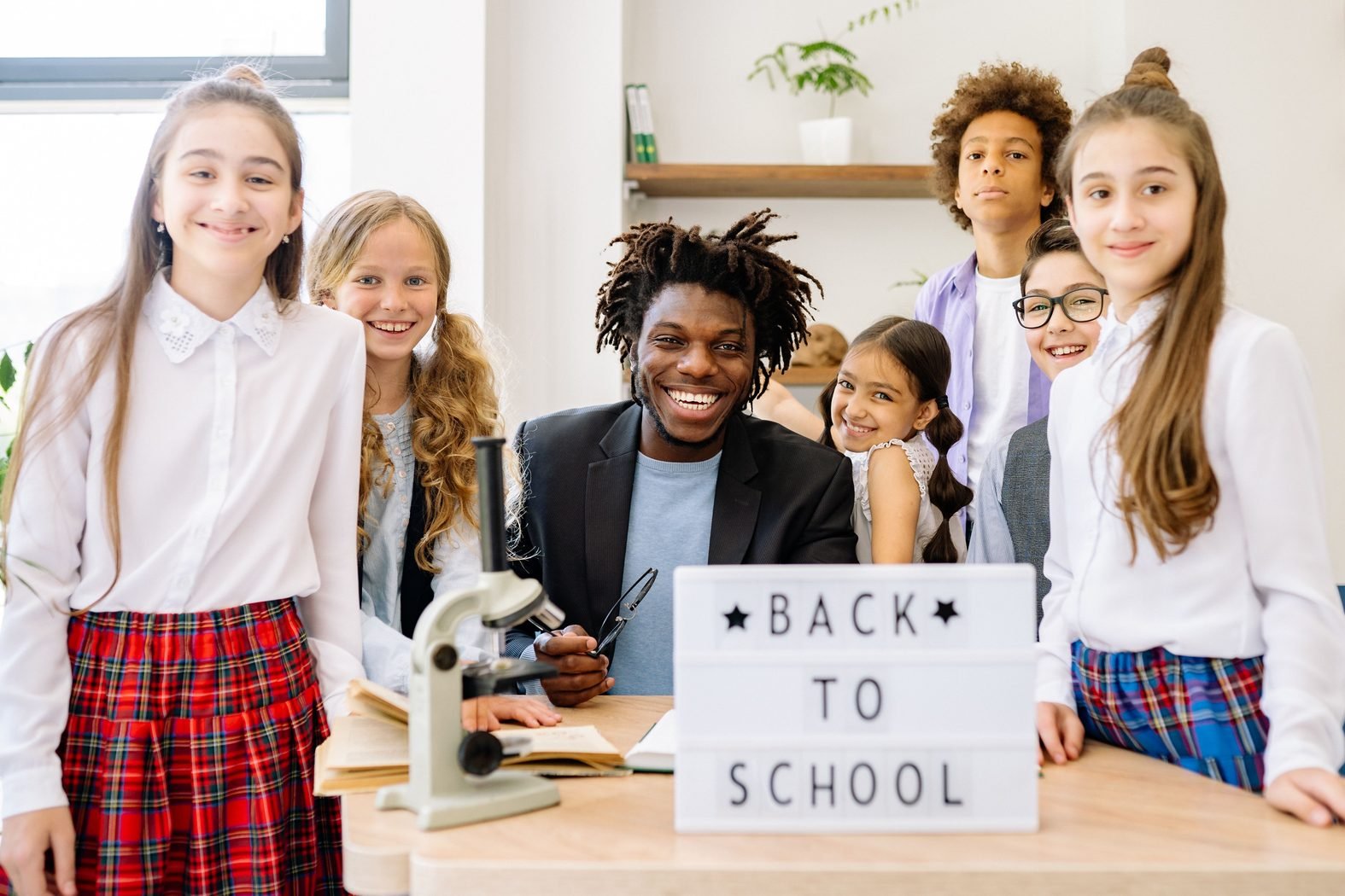 Teacher smiling with a diverse group of school children in a bright classroom