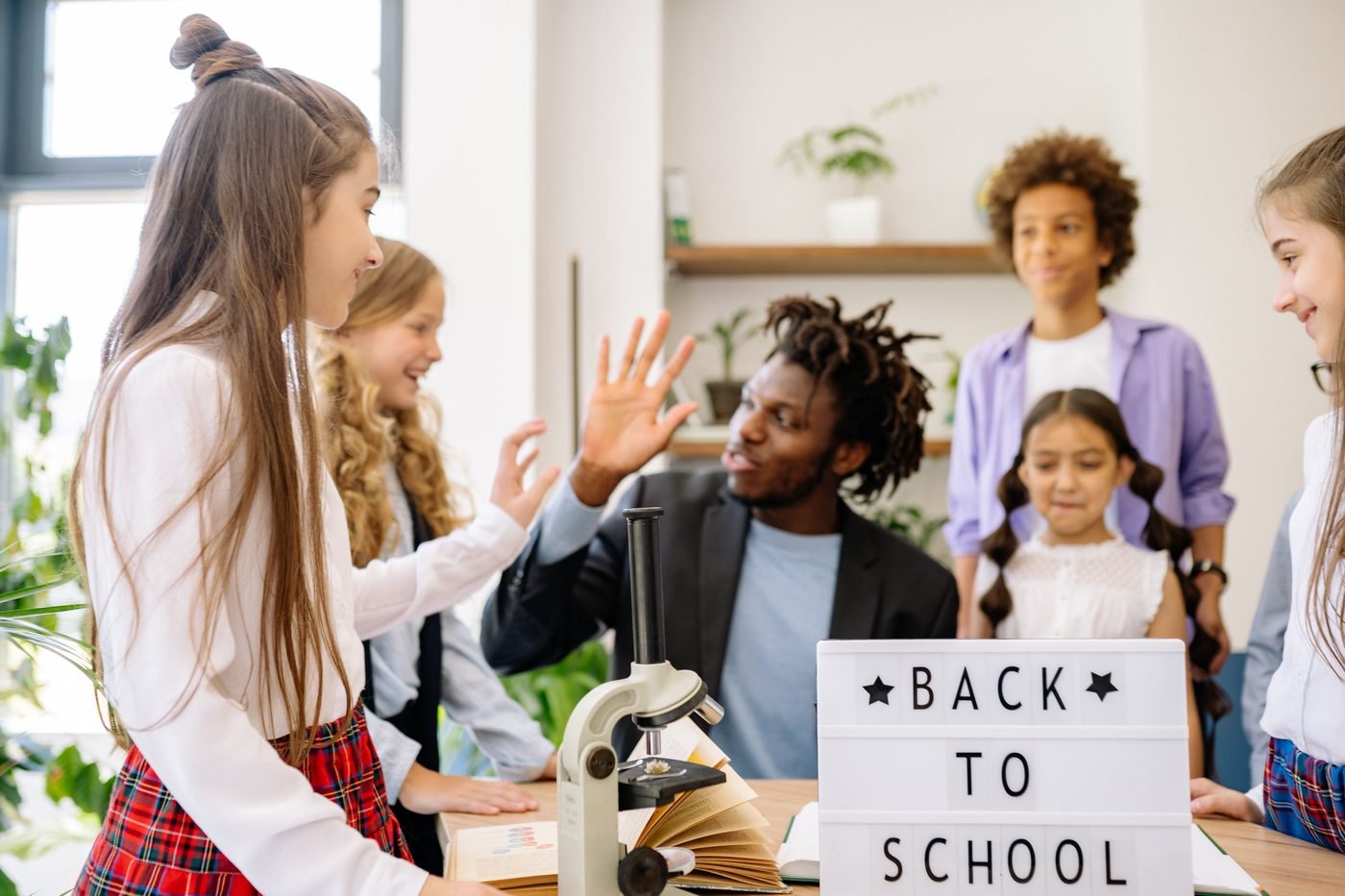 Teacher sharing a high five with a student during a classroom activity