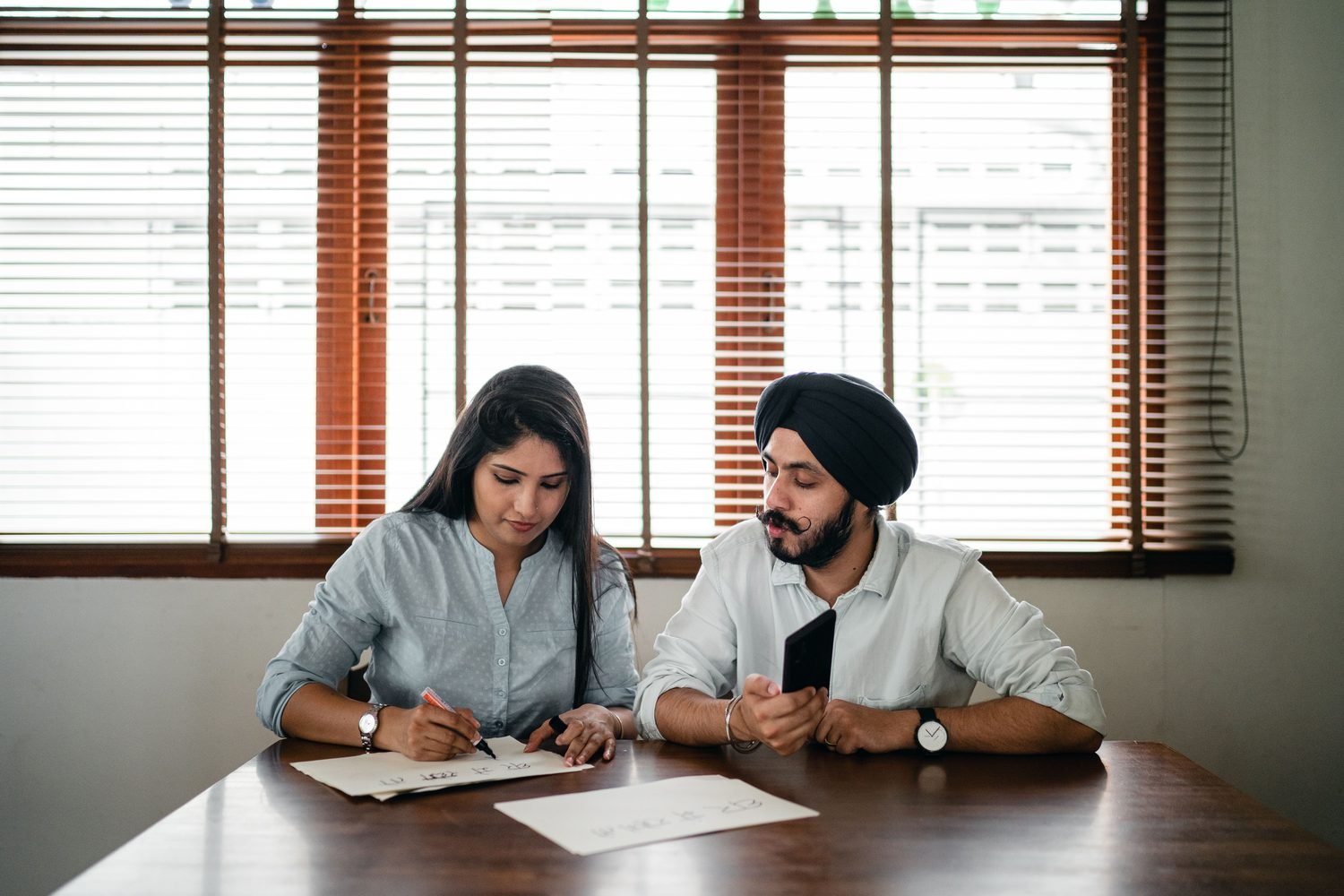 Indian woman planning a project at a table with a colleague