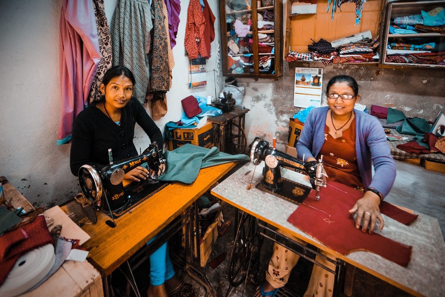 Women entrepreneurs working with sewing machines in an Indian tailoring workshop