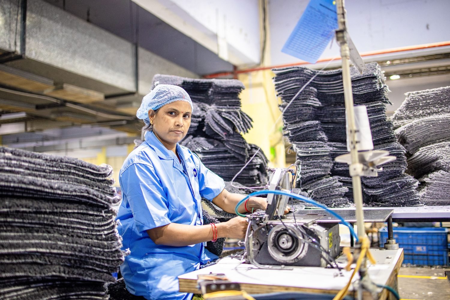 Indian woman operating an industrial sewing machine in a textile workplace